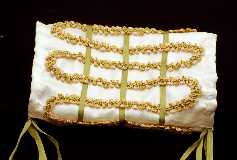 An American Girll doll muff cover in white silk covered in green french ribbon braid