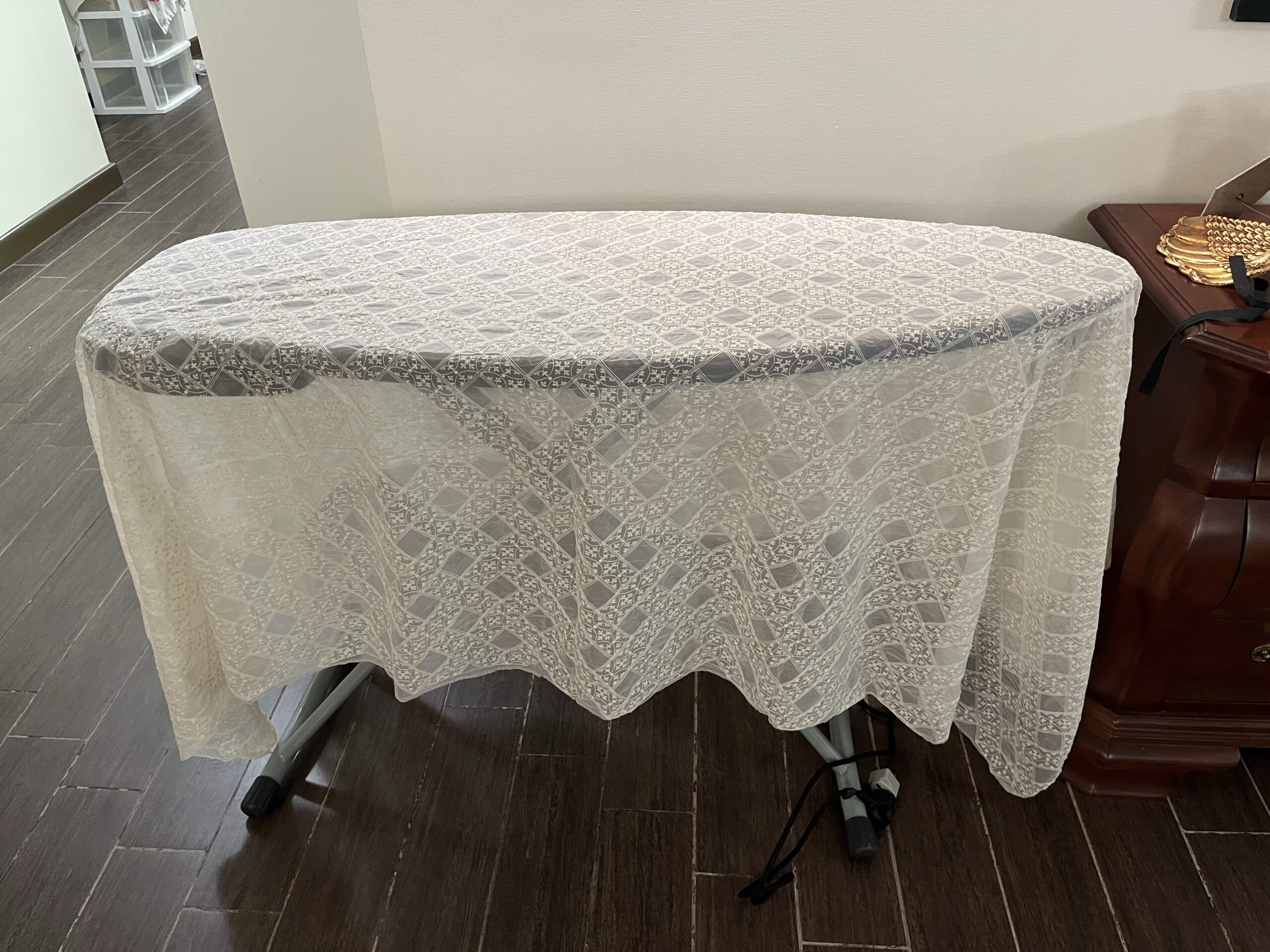 A length of cross-barred silk gauze lies draped across an ironing board