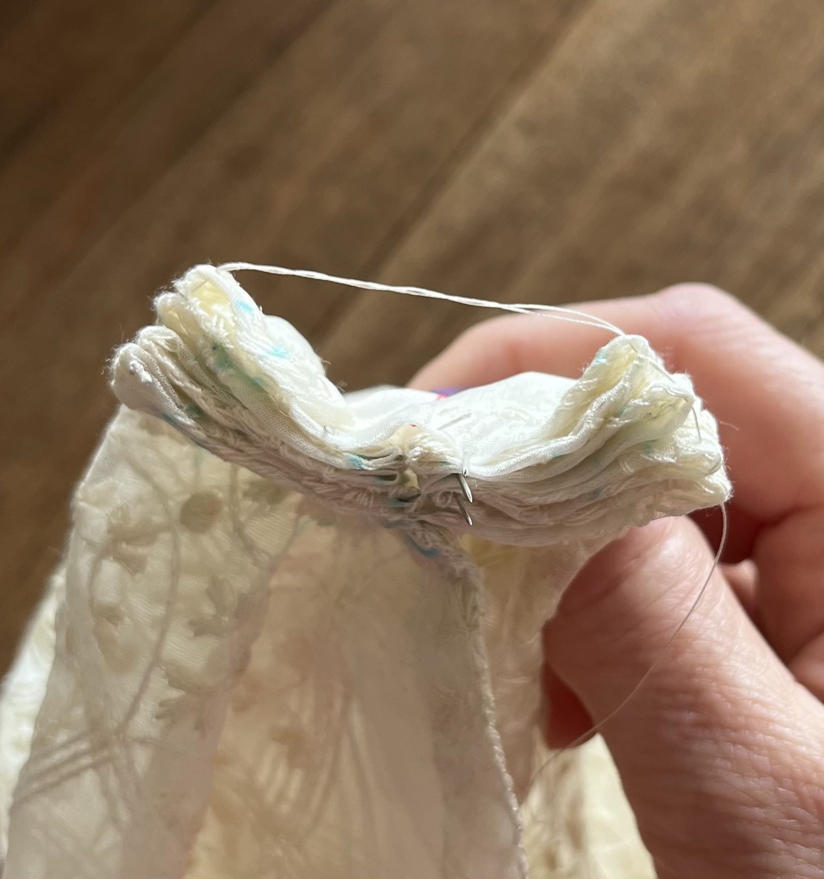 A hand holds a double stack of box pleats