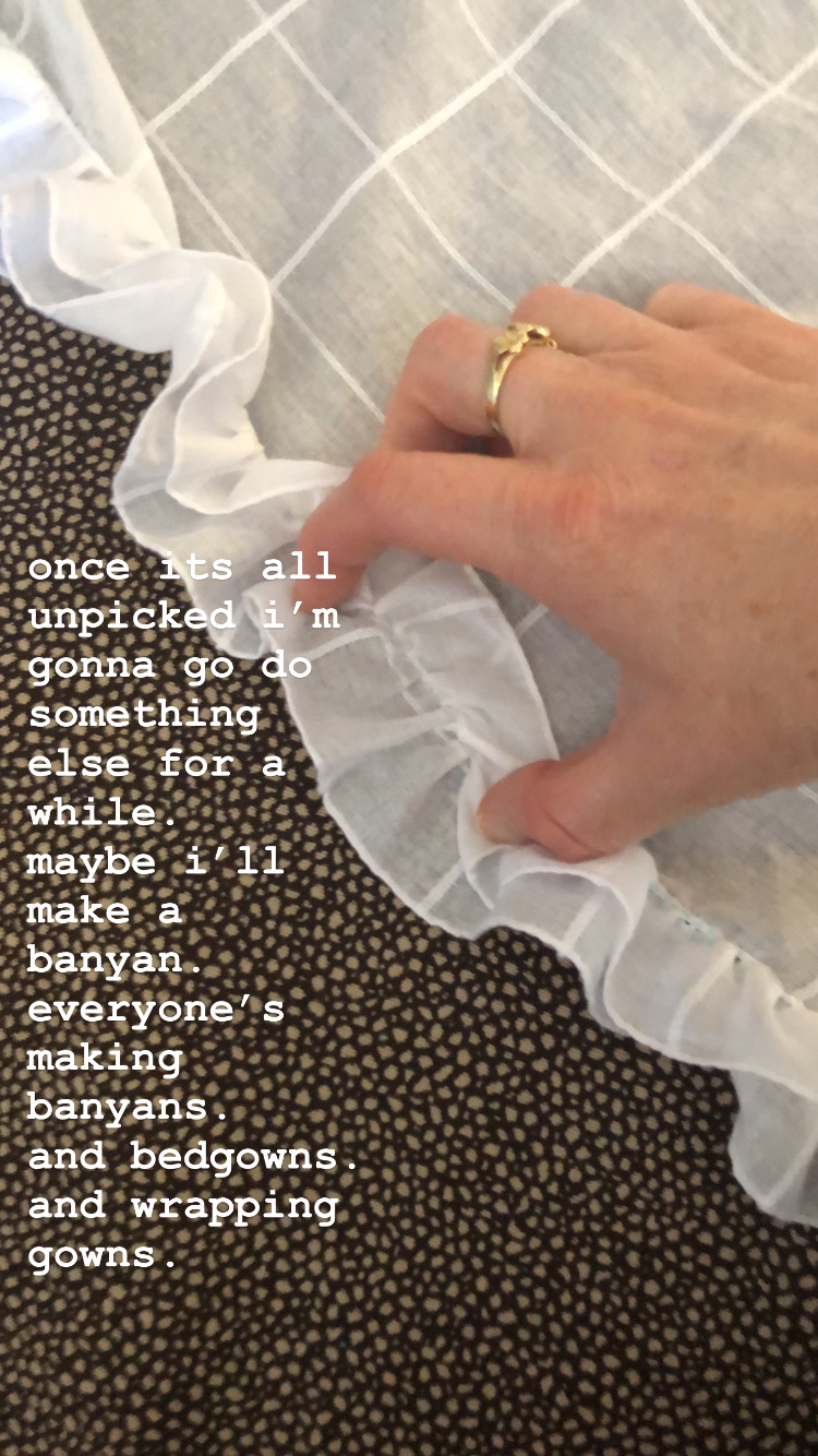 A hand holds down the ruffle on a white cotton mantelet. Text is across the image
