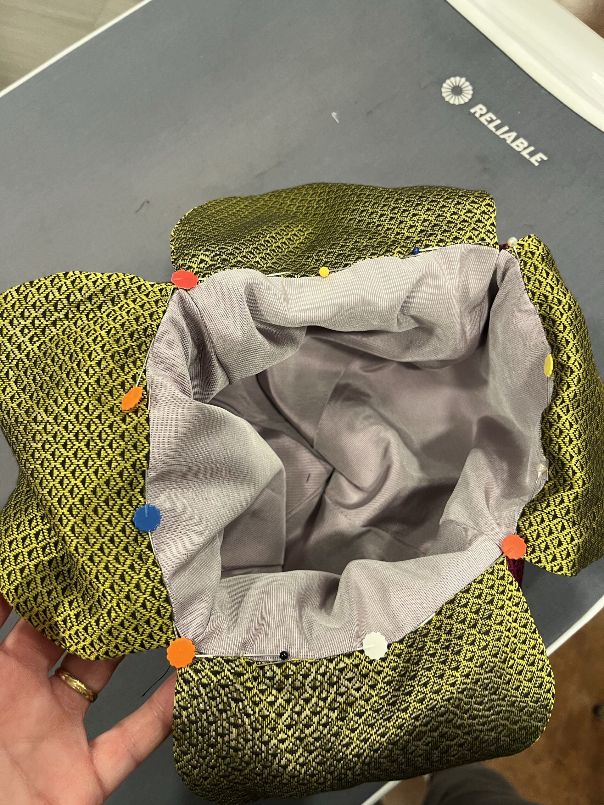 Close-up of the opening of a silk reticule - the opening is marked with large colored pin heads