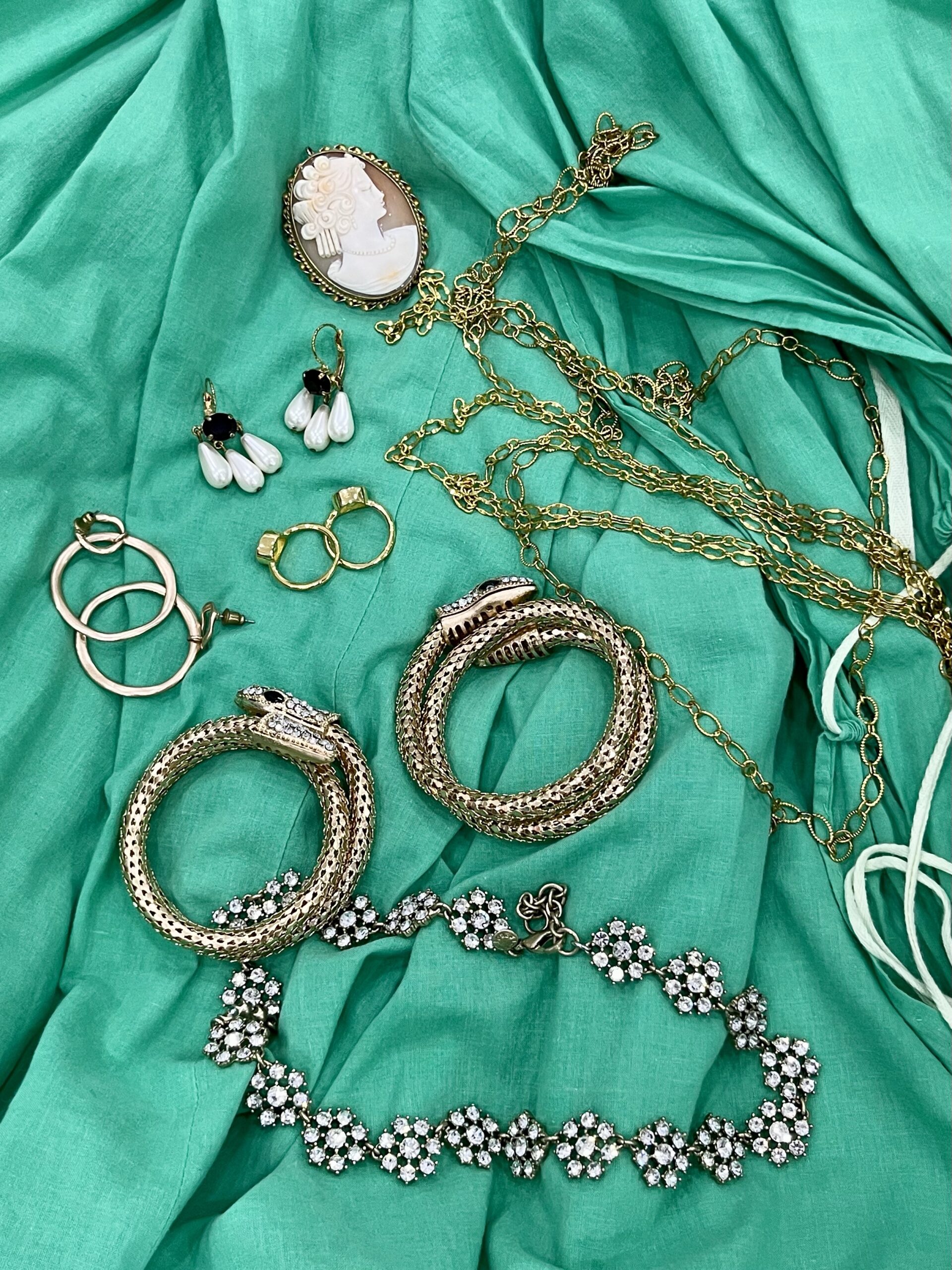 a pile of costume jewelry lying on green fabric