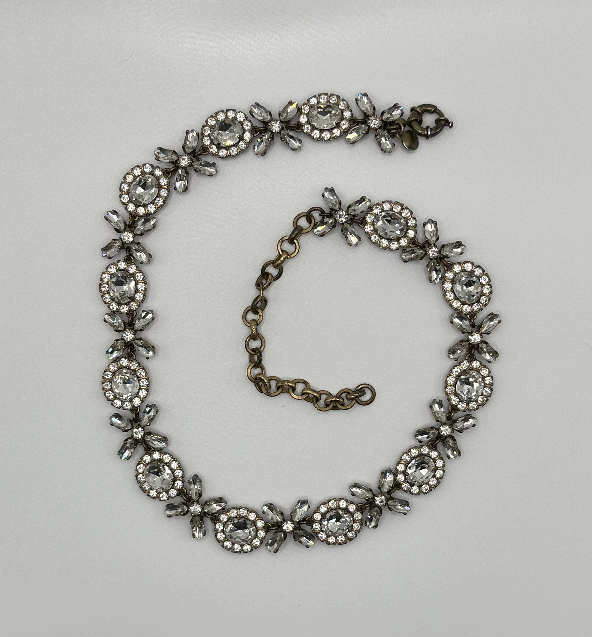 A J.Crew rhinestone necklace laid out in an alternating hug-and-kiss design