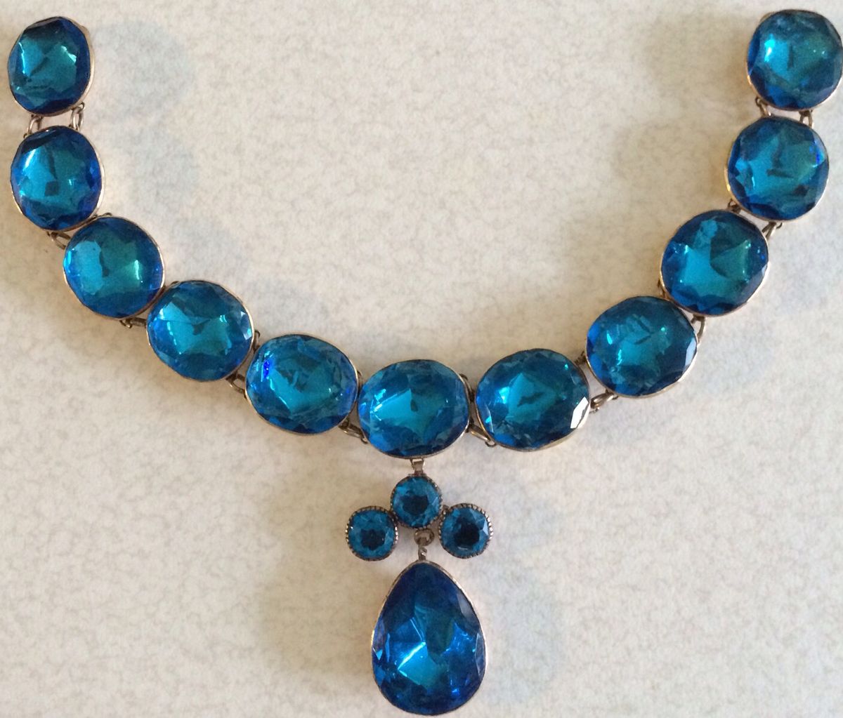 A blue queen anne style paste necklace with a blue pendant drop