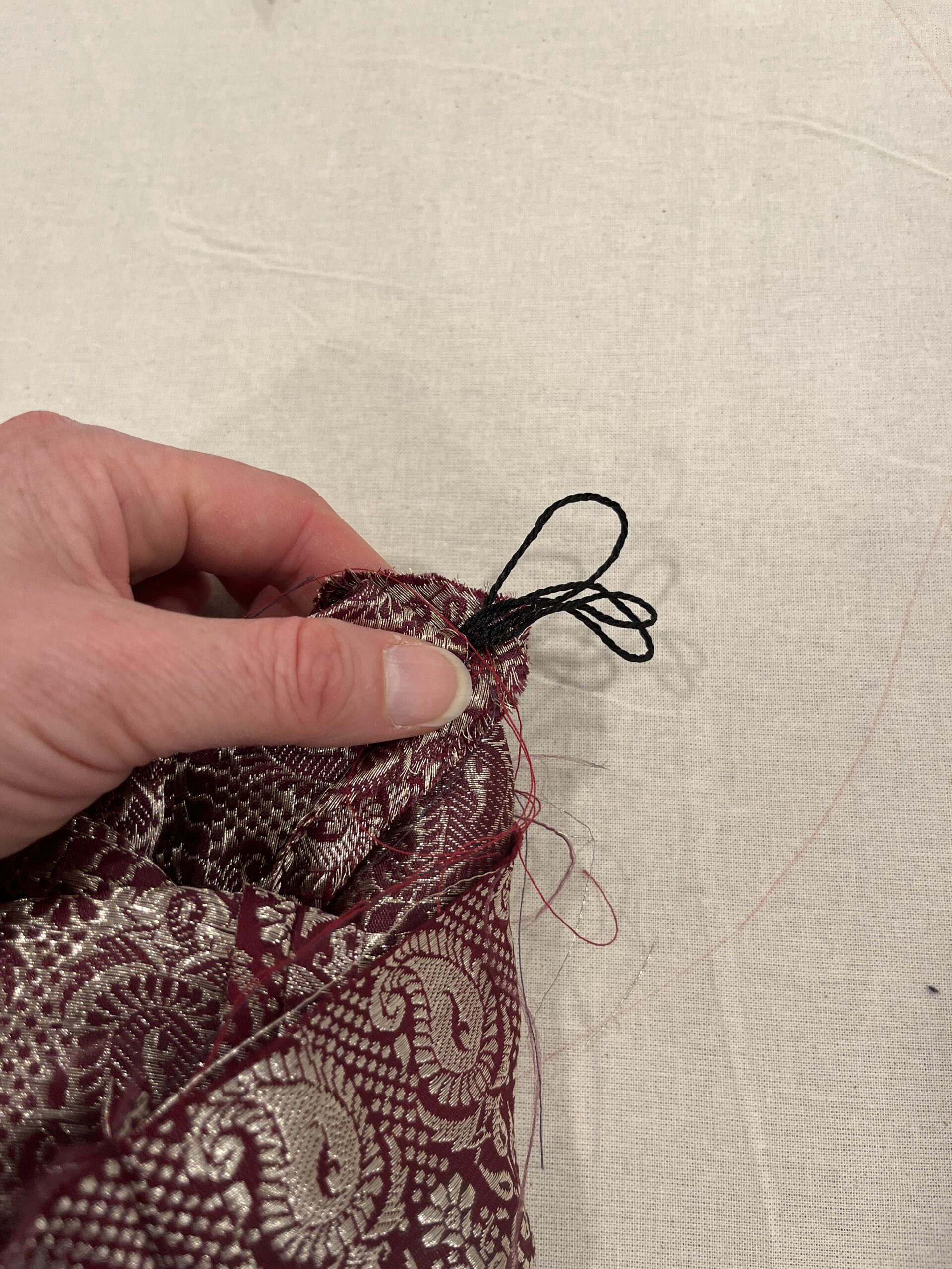 a bundle of tassel stems protrude into the inside of a reticule