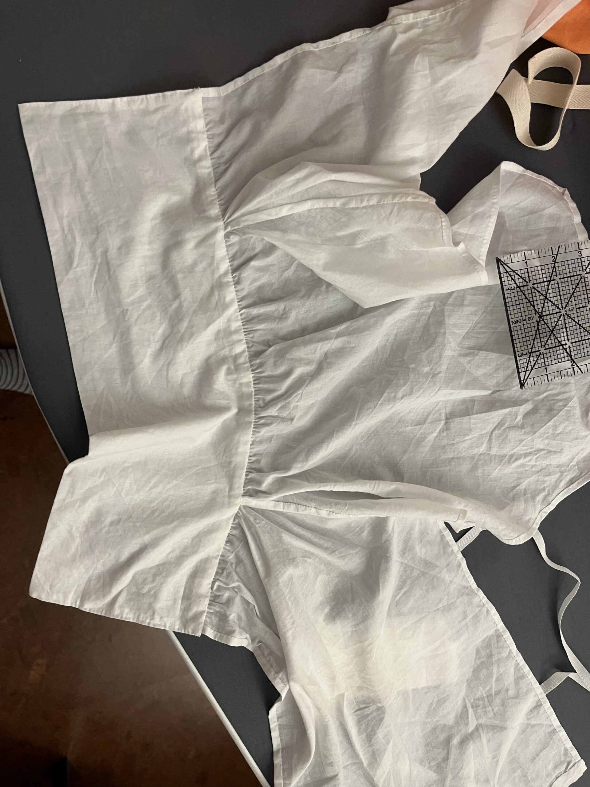 A 1790s chemisette lies spread out on a table