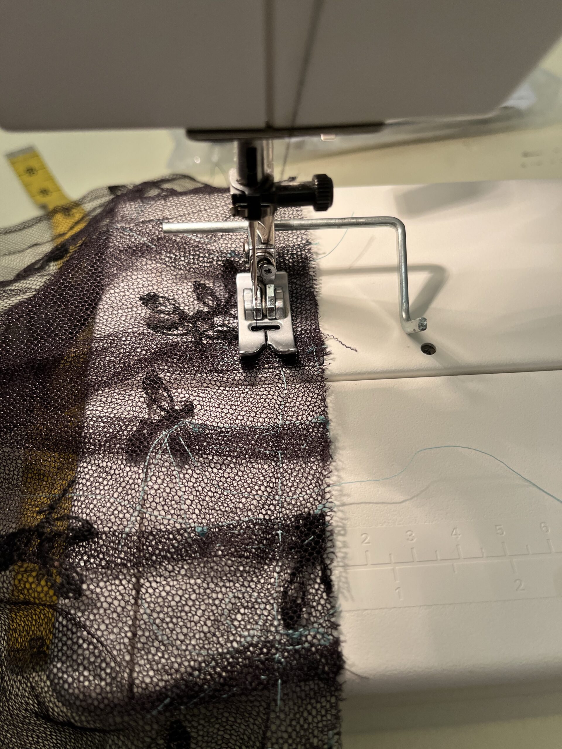 Two pieces of net fabric being stitched together on a sewing machine
