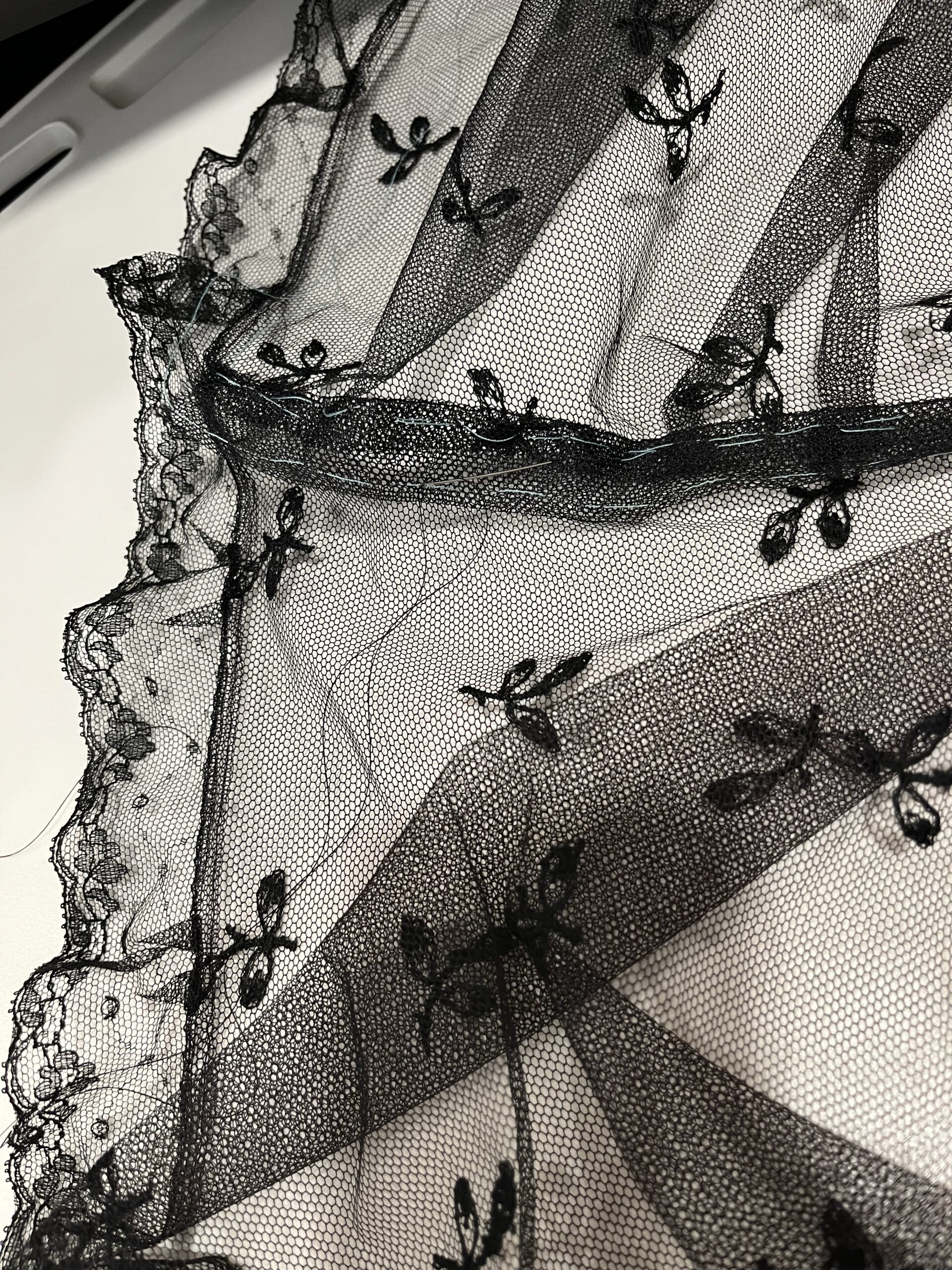 Close-up view of the neckband facing being sewn onto a net mantelet