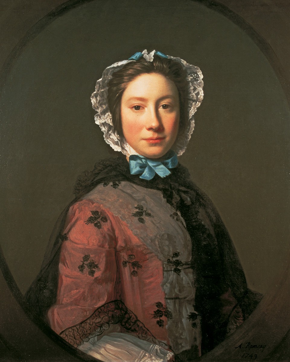Half view of a young woman wearing a red English gown and white kerchief, a white lappet cap with blue bow, and black lace cloak