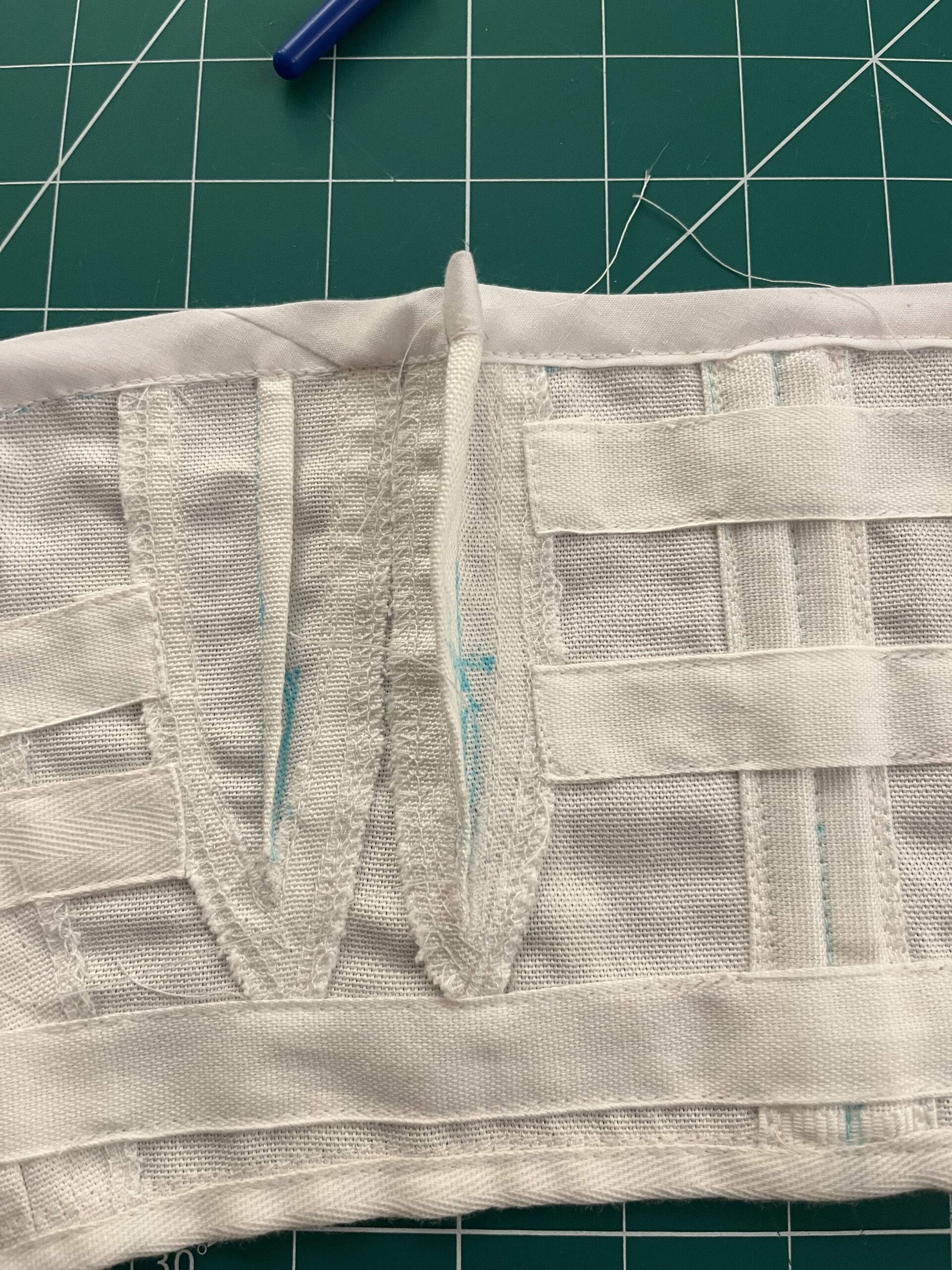 Close up of a set of white cotton bust cups. The bust cups have been pinched in with darts