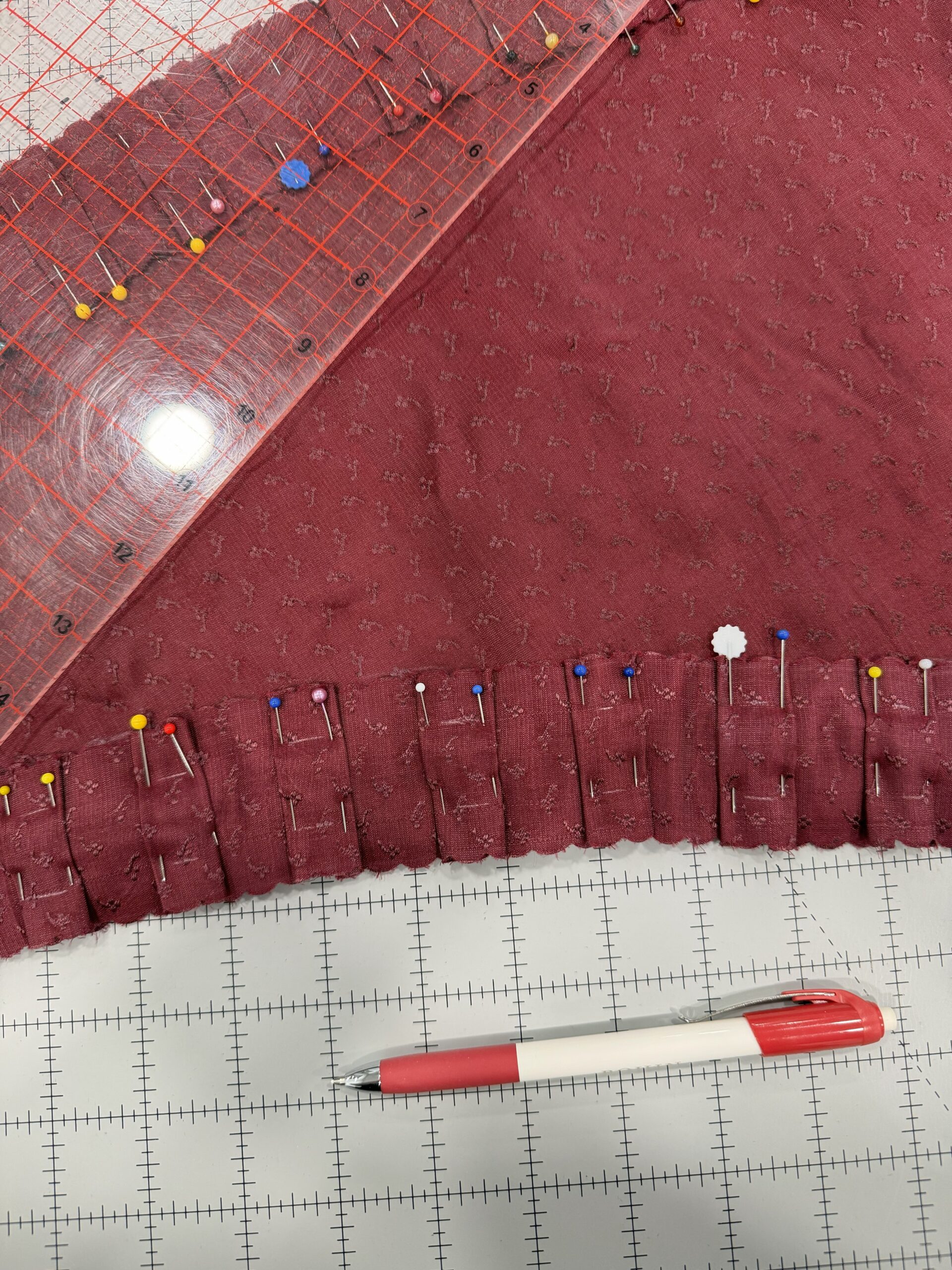 pinked pleats pinned to a red mantle