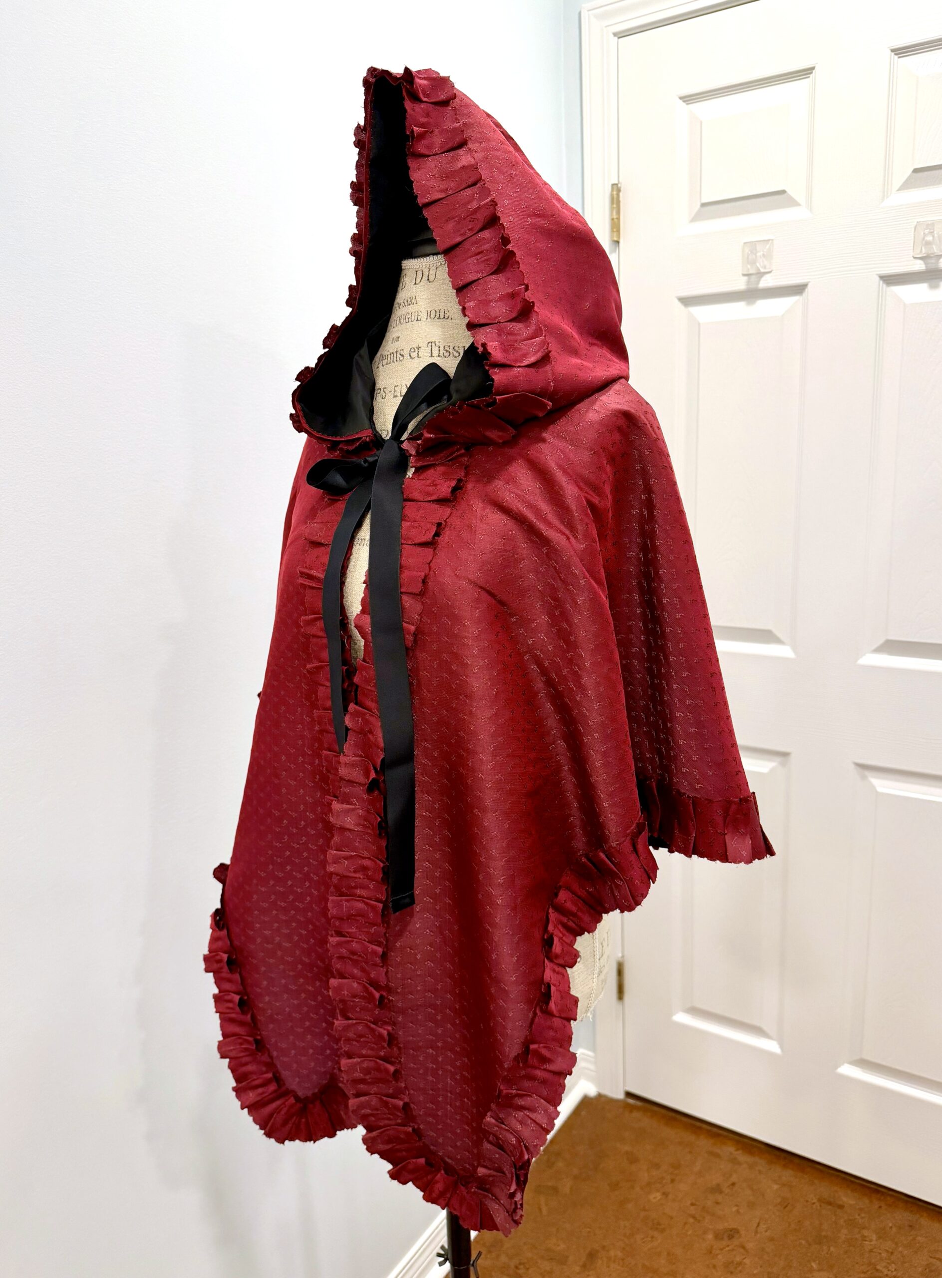 3/4 view of the Scroop Charlotte Mantle sewn from figured burgundy silk