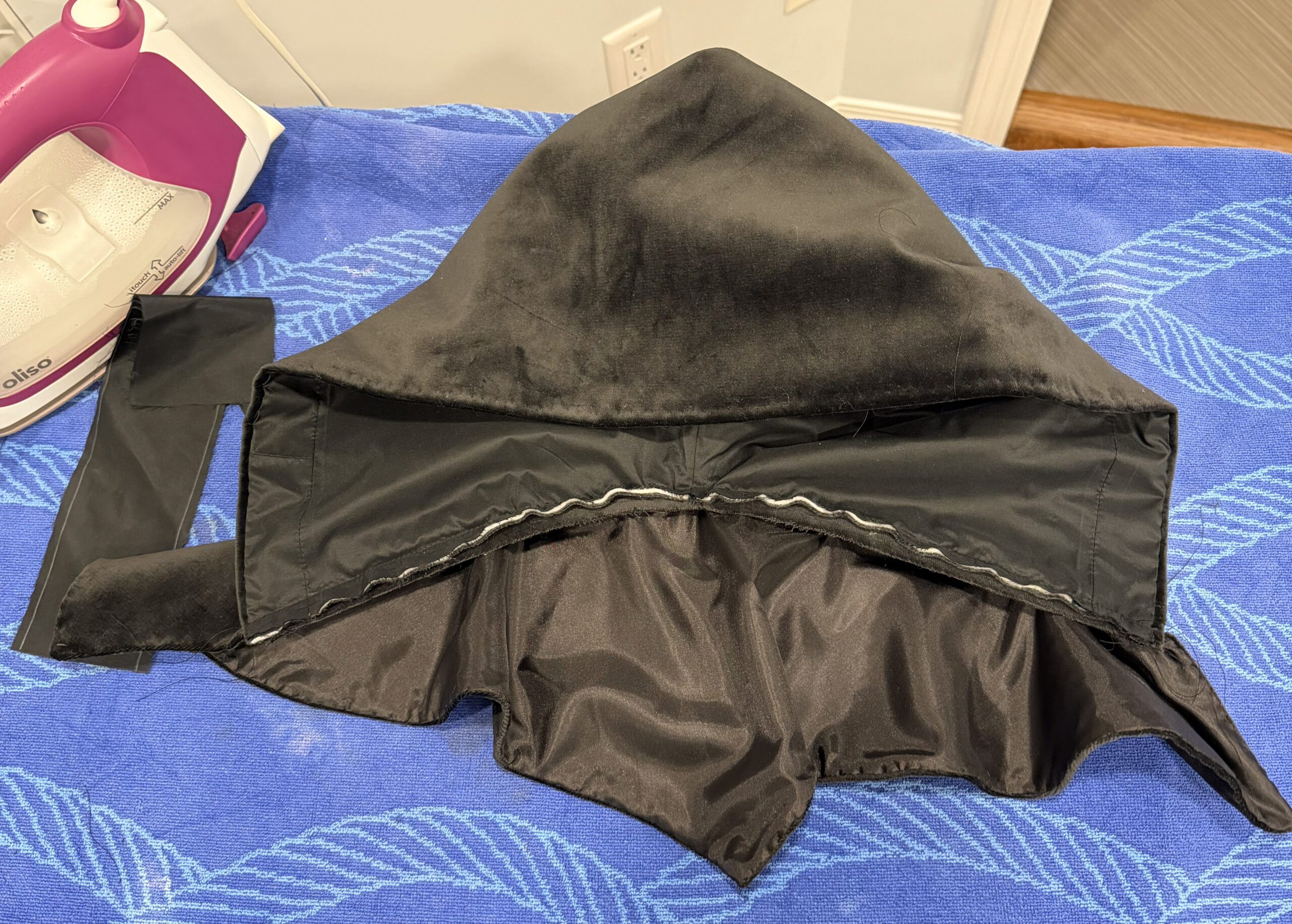 hood body stitched to cape, showing raw seam