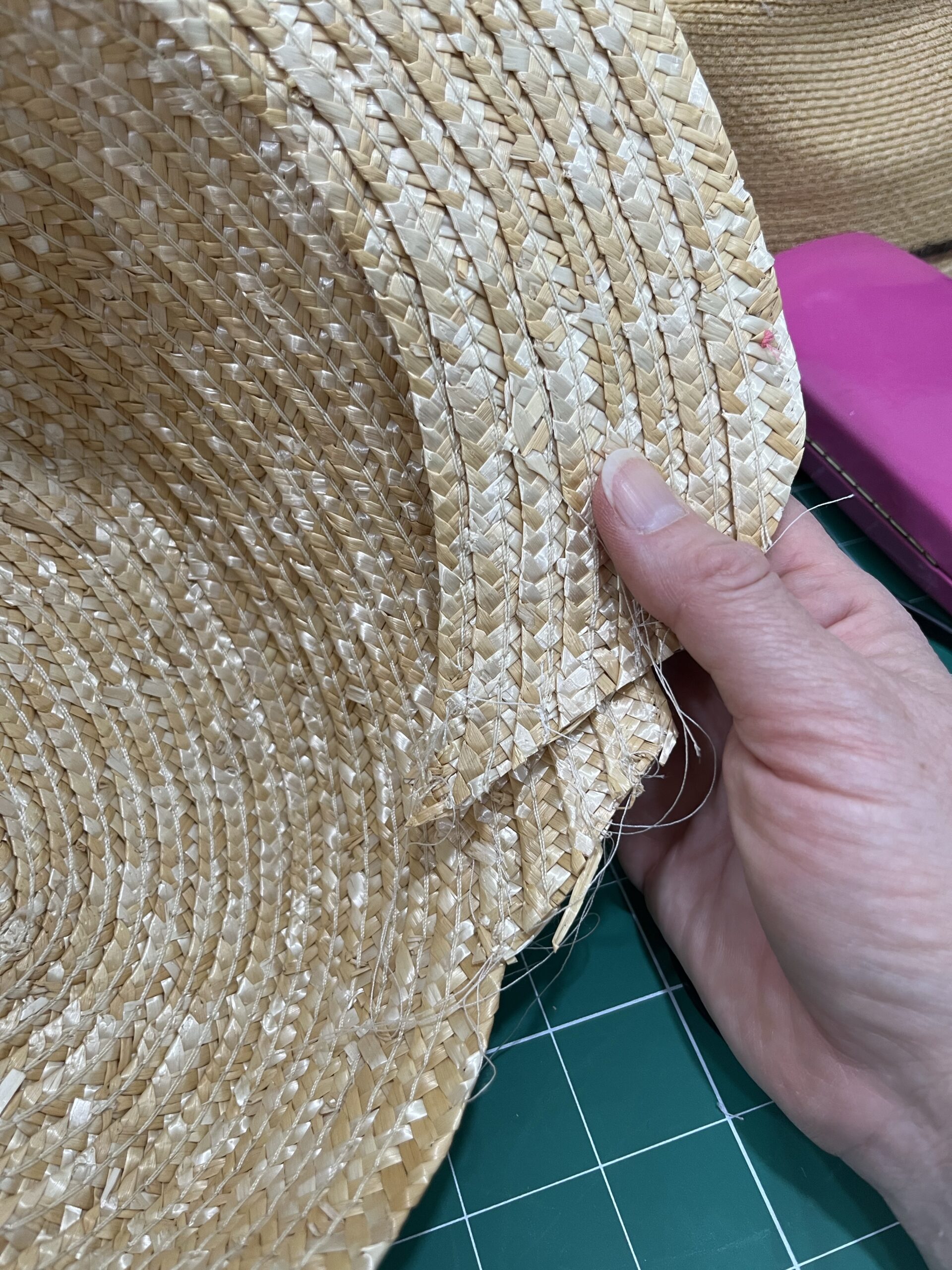 an inside view of a hat with a partially unpicked brim folded under the crown