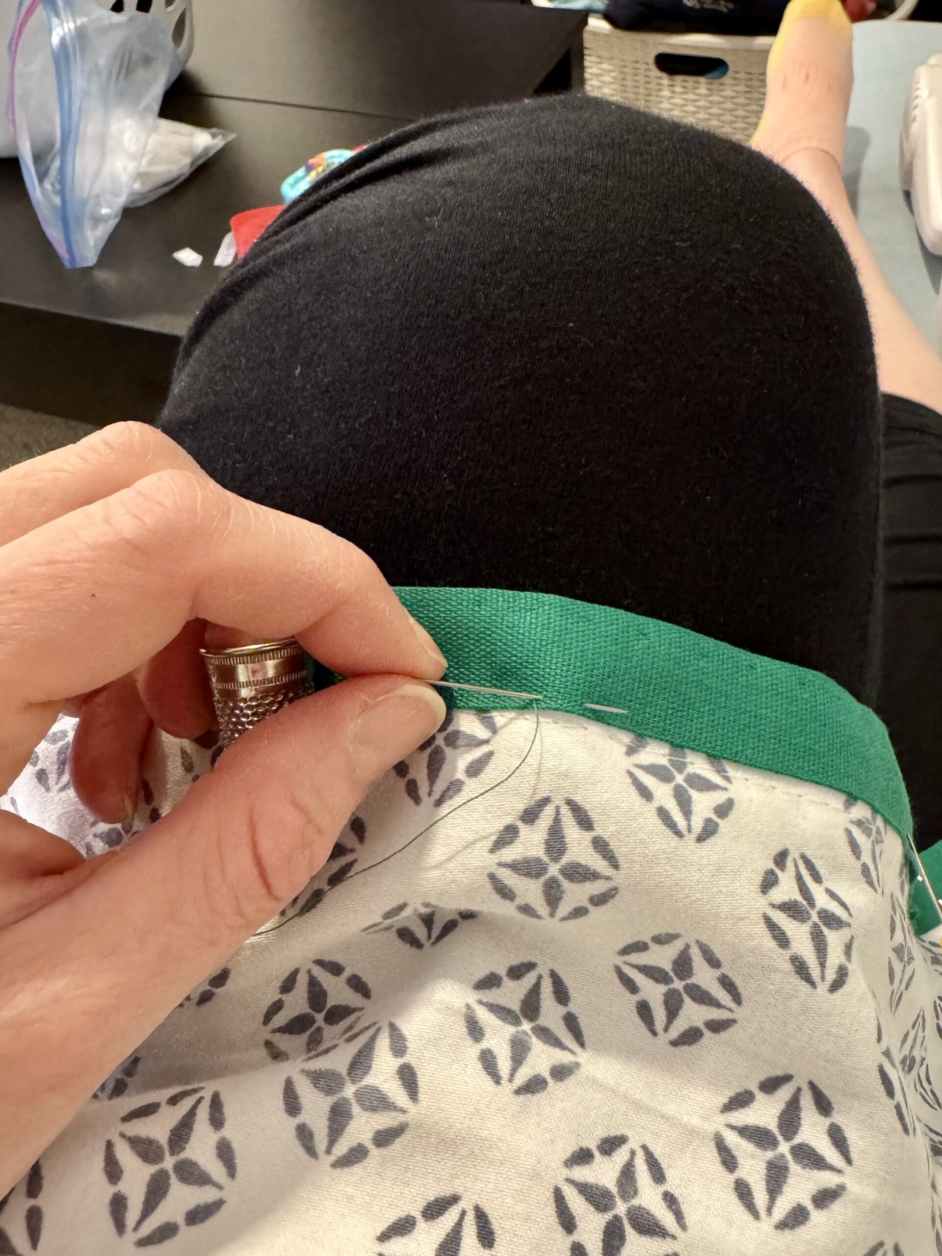 close up of an emerald green racing stripe being stitched onto block printed fabric