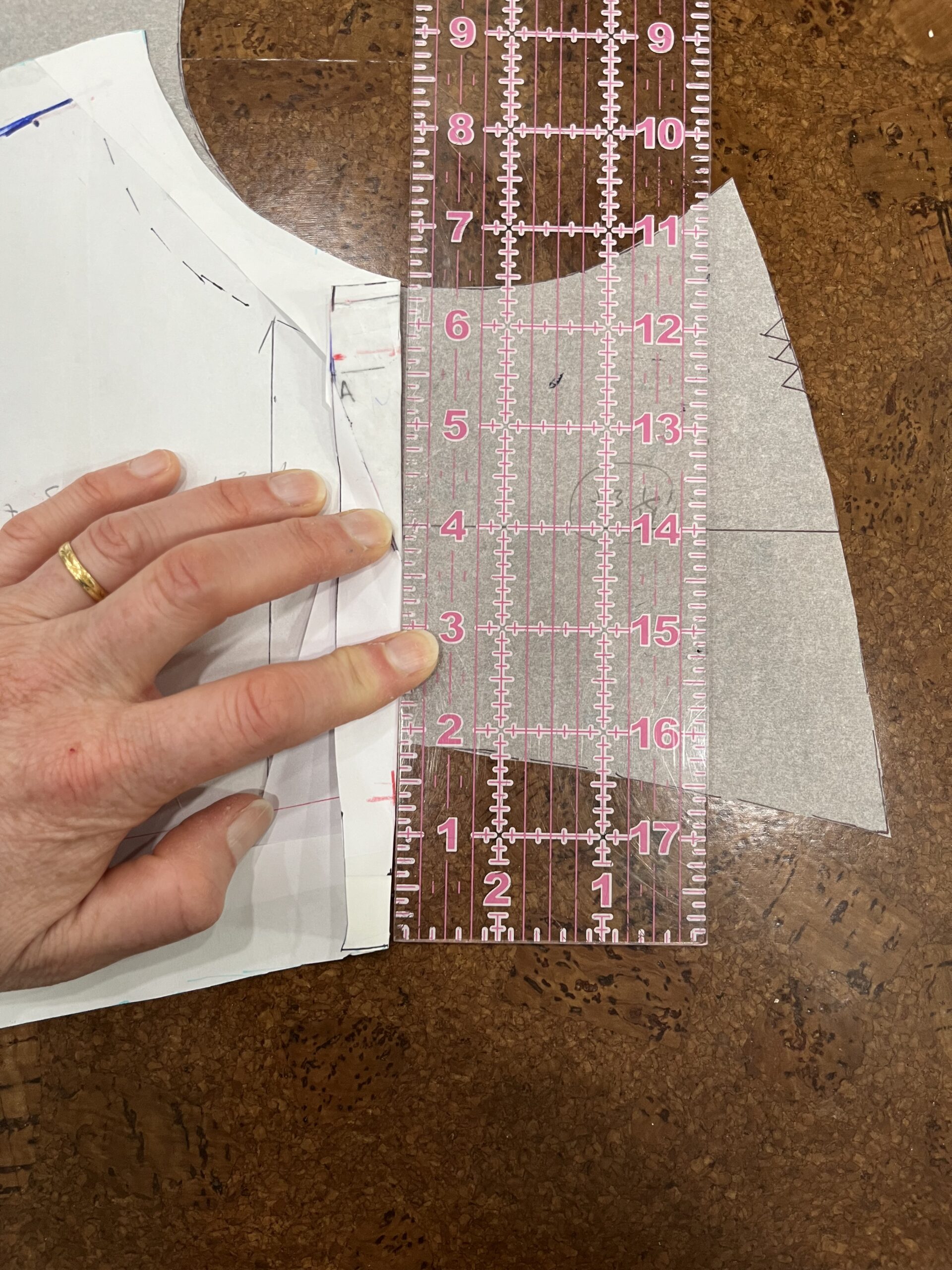 two paper pattern pieces lie next to each other edge to edge. A large clear ruler shows that One is two inches shorter than the other